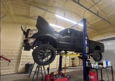 Real photo of a truck up on the lift at K&H Mechanics