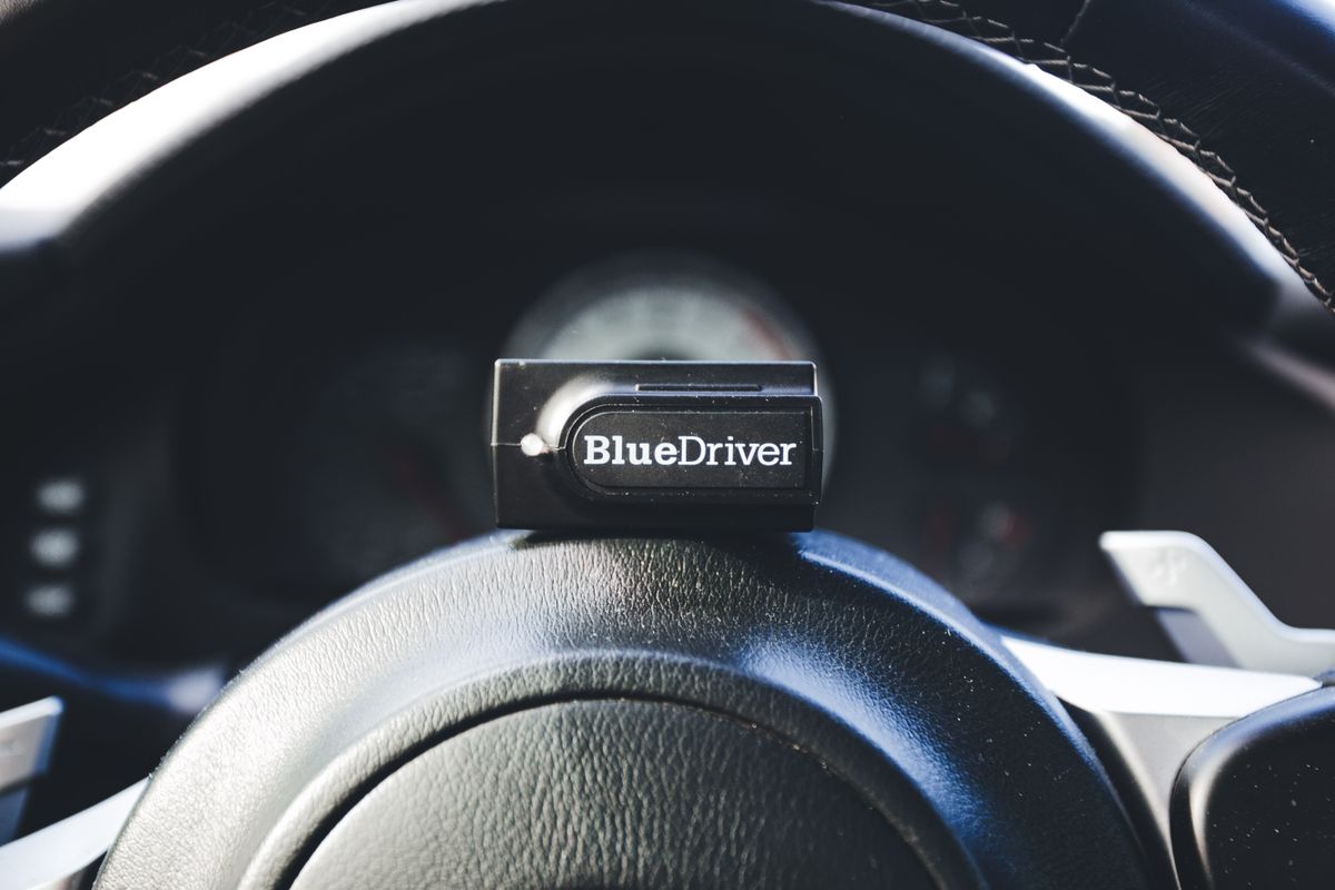 OBD2 diagnostic code reader plugged into a vehicle, stock photo